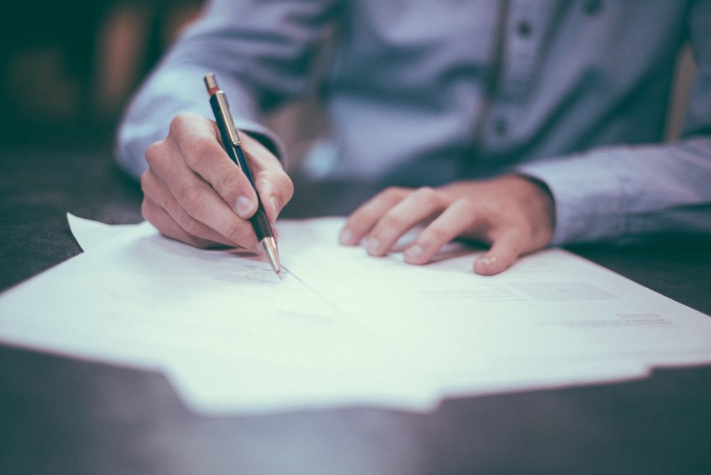 a man writing a personal statement with a pen